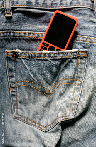 close up of dumb phone in the back pocket denim pant