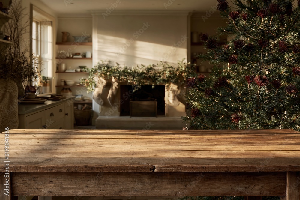 Naklejka premium Empty rustic wooden table in a cozy living room with a Christmas tree and hearth, featuring weathered textures and copy space for a product mockup
