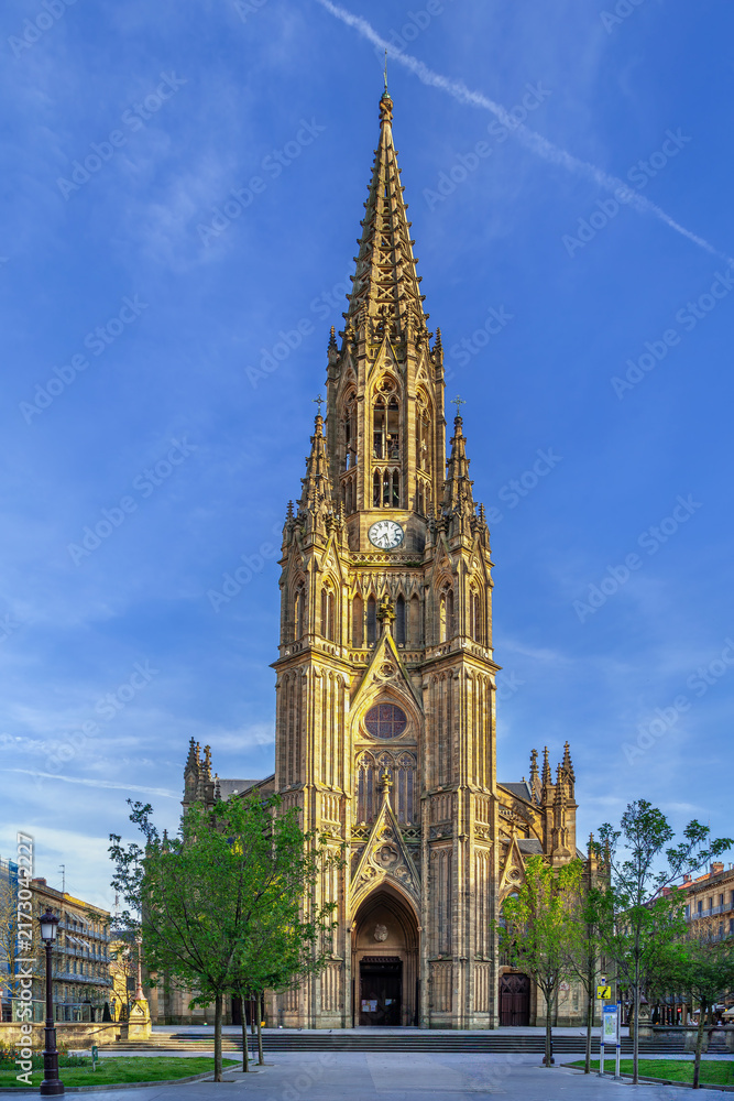 Obraz premium Cathedral of the Good Shepherd facade in San Sebastian, Spain. Low angle view. Sunny daylight, blue sky. Neo Gothic style