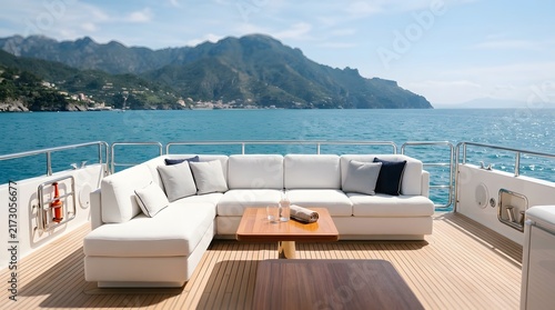 White lounge sofa on luxury yacht deck with ocean view and mountain landscape background