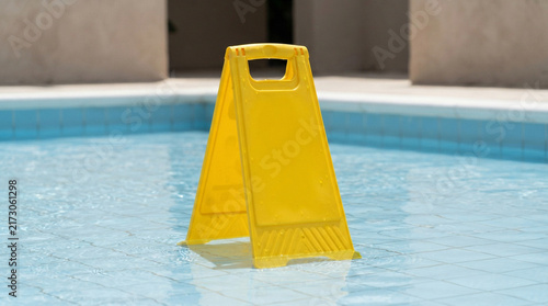Yellow blank caution sign in a swimming pool
