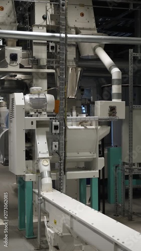 Vertical video. Automated conveyor system moving raw materials through a modern, clean industrial plant, highlighting efficient manufacturing technology, machinery and production line automation