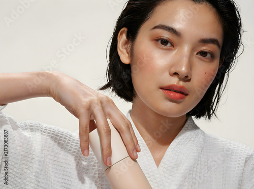 Close-up portrait of an Asian model touching her skin for beauty or skincare advertising