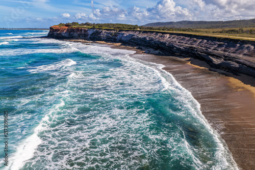 Foto Aerial view of the rugged rocky cliffs and sandy shoreline of Lake Arragan Beach