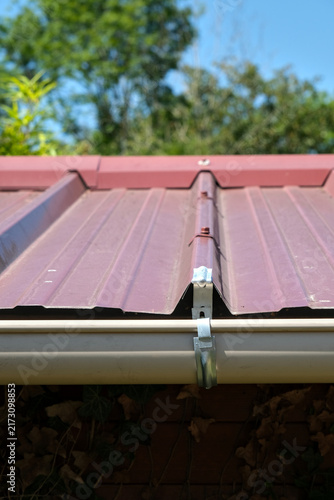 Konstfotografi Galvanized steel gutter fixing bracket mounted on corrugated metal roofing for rainwater drainage installation