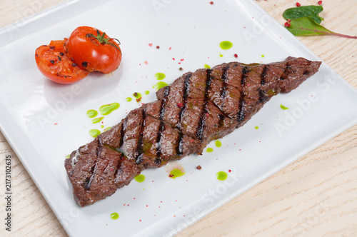 Quadro su tela Grilled flank steak with grill marks, roasted tomatoes, and pink peppercorns on