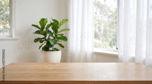 Empty wooden table top mockup with blurred minimalist home interior background for product presentation and display.