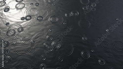 Raindrops falling on calm dark water creating expanding circular ripples with soft reflected daylight, moody seamless loop background with copy space