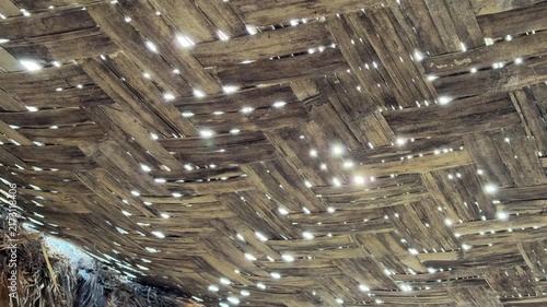 Sunlight Shining Through a Traditional Bamboo Roof Structure

