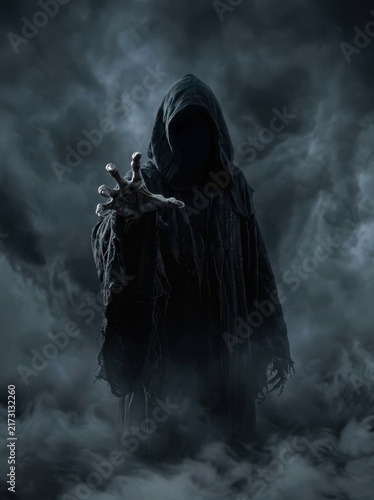 Scary hooded grim reaper figure reaching out with a hand in dark misty smoke for a spooky halloween horror atmosphere and theme