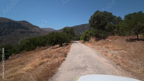 A car drives slowly along a dangerous winding mountain road on the island of Crete, Greece.