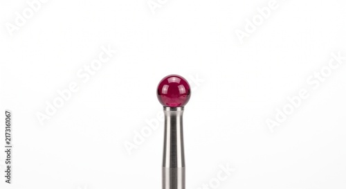 CNC machine touch probe tip with spherical ruby gem and stainless steel stylus. Macro metrology and calibration hardware isolated on pure white background for industrial manufacturing.