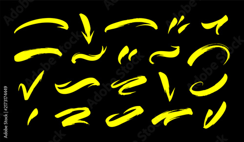 Yellow hand drawn arrows and brush strokes isolated on black background for highlighting