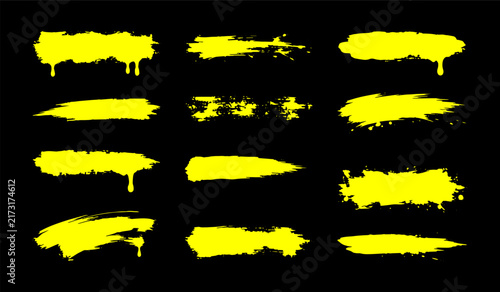 Yellow ink paint brush strokes with drips set isolated on black background