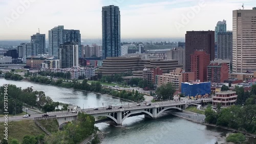 hovering in front of historic Centre St Bridge crossing the Bow River, in Downtown Calgary, Alberta, Canada, with traffic passing over the bridge in both directions. Cityscape of Downtown 