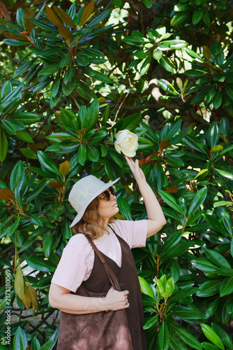 Woman Touching White Magnolia Flower on Tree in Park