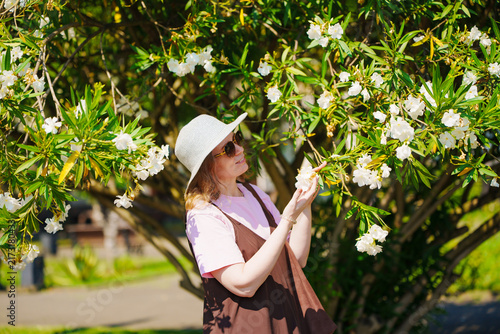 Medium Portrait of Smiling Woman with White Oleander Blossoms
