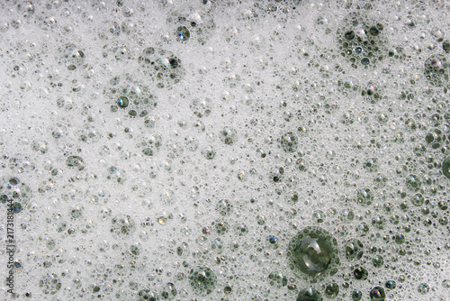 Konstfotografi Rich layer of white foam filled with countless bubbles showing iridescent rainbow colors on thin surfaces
