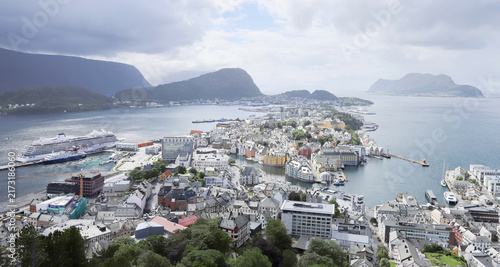 Aerial panoramic view of Alesund town from Aksla hill in Norway. Spectacular landscape of a Norwegian coastal city under dramatic cloudy sky.
