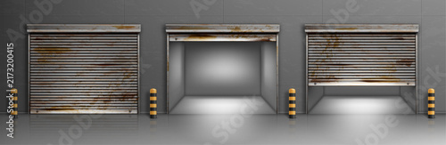 Industrial garage doors with rust and bollards against a gray concrete wall