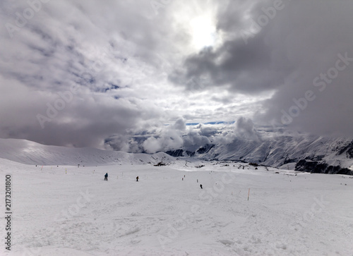 Skiers on ski slope before rain