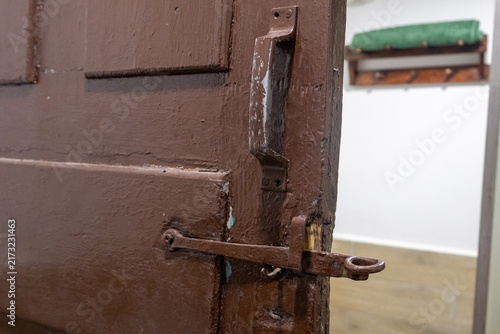 Obraz na plátne Weathered brown wooden door with rusty metal latch in domestic interior rustic s