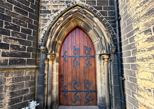Foto A wooden door adorned with intricate metalwork set in a gothic arch