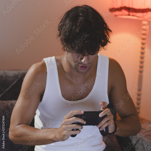 Картината върху платно Young man engrossed in playing video games.