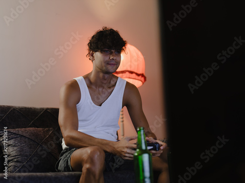 Fotografie Young man engrossed in playing video games.