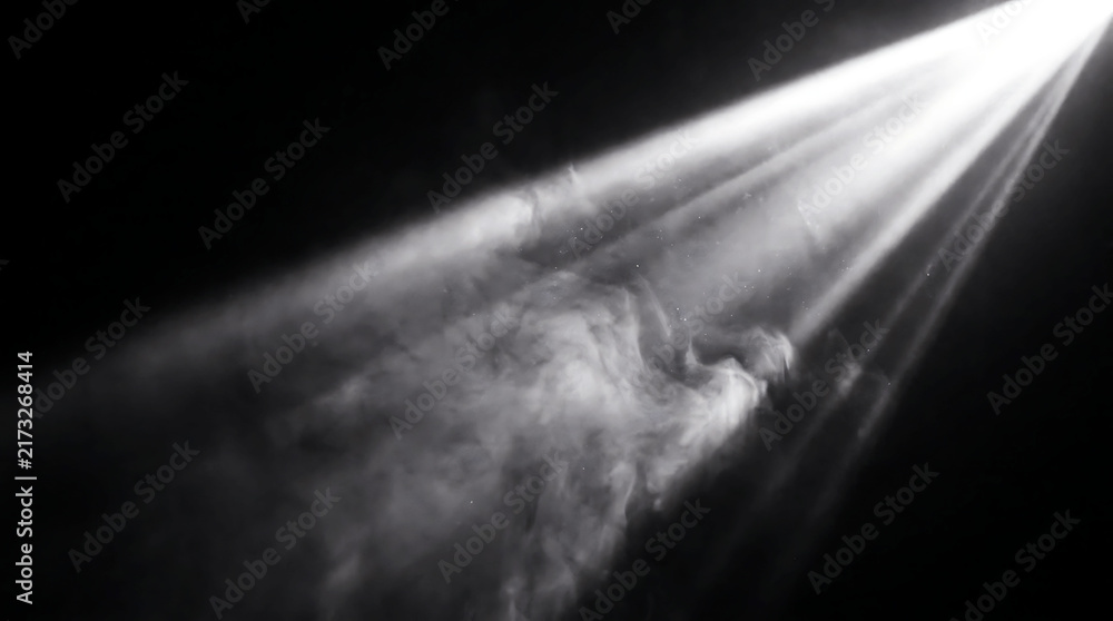 Obraz premium Bright white spotlight beams cutting through dense smoke on a dark stage