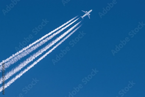 The Airplane Soaring Through a Clear Blue Sky with White Contrails