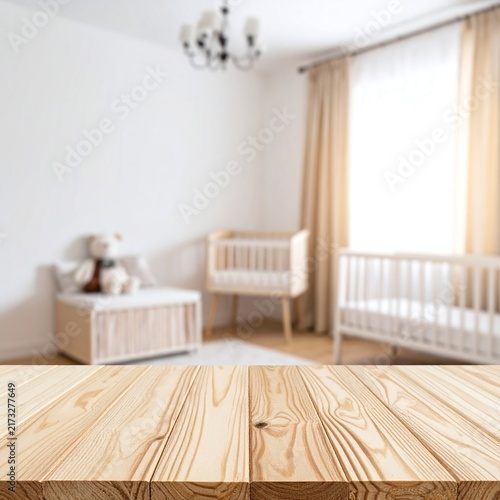 Empty wooden table with minimal blurred baby nursery background