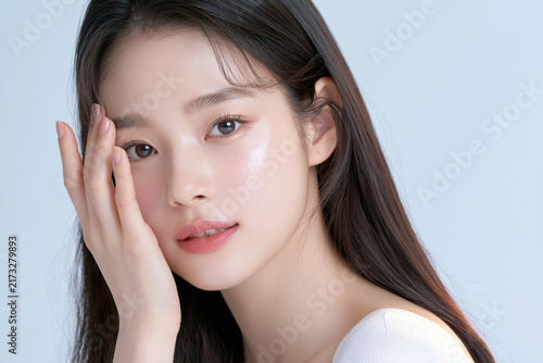 A close-up portrait of a young woman with radiant skin and delicate features, embodying beauty and natural elegance.