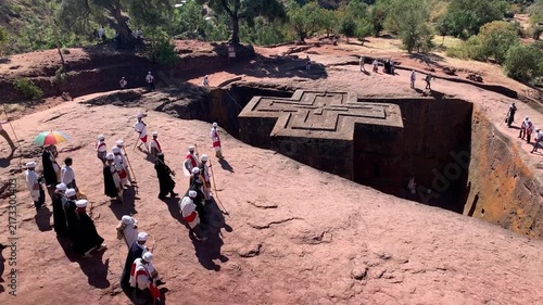 Ethiopia - 26 August 2026: View of the rock-hewn Church of Saint George in Lalibela with people in traditional white robes walking on the surrounding volcanic rock.