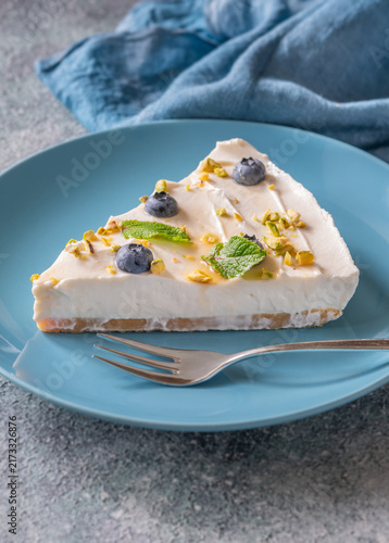 Creamy Mascarpone Cheesecake Slice Served With Blueberries Pistachios Maple Syrup And Mint Leaves