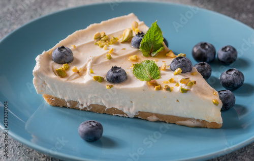 Creamy Mascarpone Cheesecake Slice Served With Blueberries Pistachios Maple Syrup And Mint Leaves