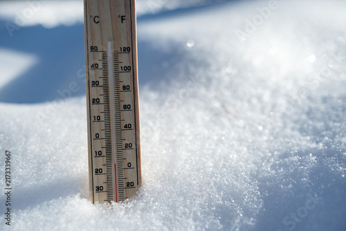Cuadro en lienzo Wooden thermometer standing in snow shows temperature below freezing on a sunny winter day