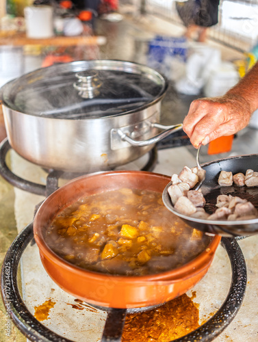 Konstfotografi Cook adding seared tuna into boiling potato stew to complete Basque Marmitako during an outdoor festival