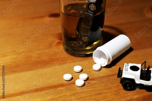 Foto Drunk driving concept with alcohol, pills, and police car