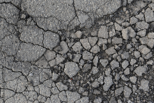 Canvastavla A mosaic of decay: asphalt fragments break apart like tectonic plates, revealing the raw, dusty impermanence of a once-smooth surface in a play of deep light and shadow