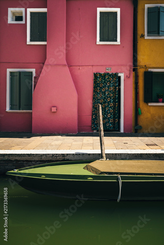 Cuadro en lienzo Colorful pink house facade and boat along a canal in Burano, Venice