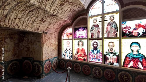 Coober Pedy, South Australia - 15 May 2025: View of the underground Serbian Orthodox Church featuring a cross-shaped baptismal font and religious iconography carved into stone walls.