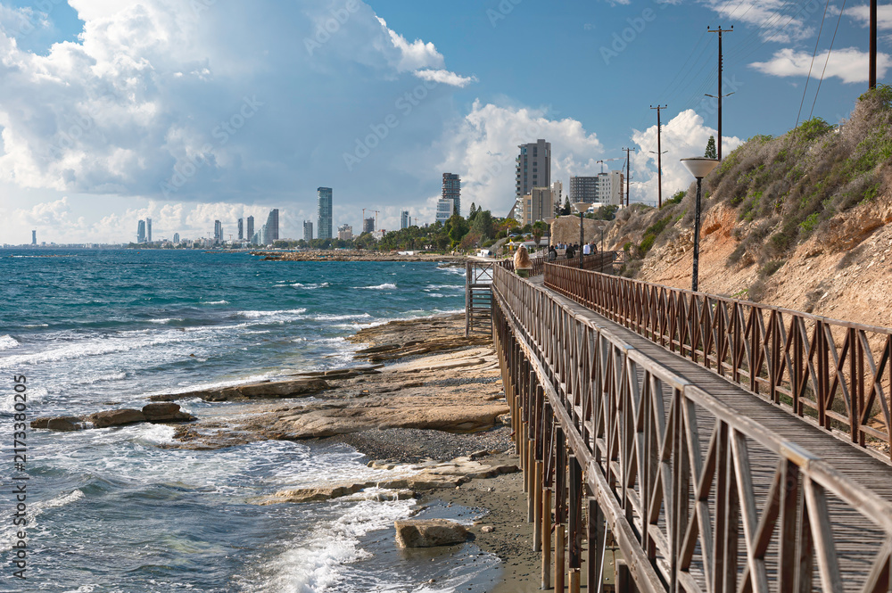 Fototapeta premium Limassol, Cyprus. Coastal boardwalk leading to modern city skyline.