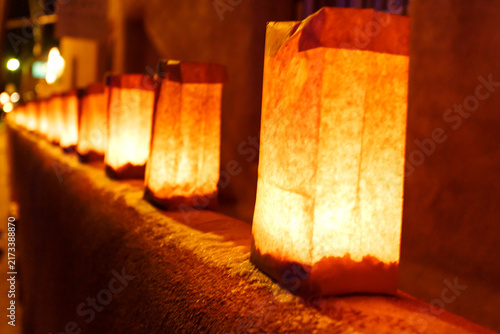 A row of luminaries are lit up on a ledge, creating a warm and inviting atmosphere.