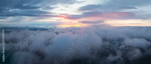 Panel kuchenny z motywem Aerial view above dramatic clouds in the Icelandic highlands at sunset, with soft golden light, misty valleys and a vast remote landscape hidden beneath the clouds.