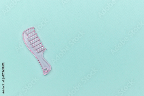 Obraz na plátne Minimalist Pink Comb on Light Blue Background: Aesthetic Haircare Essentials