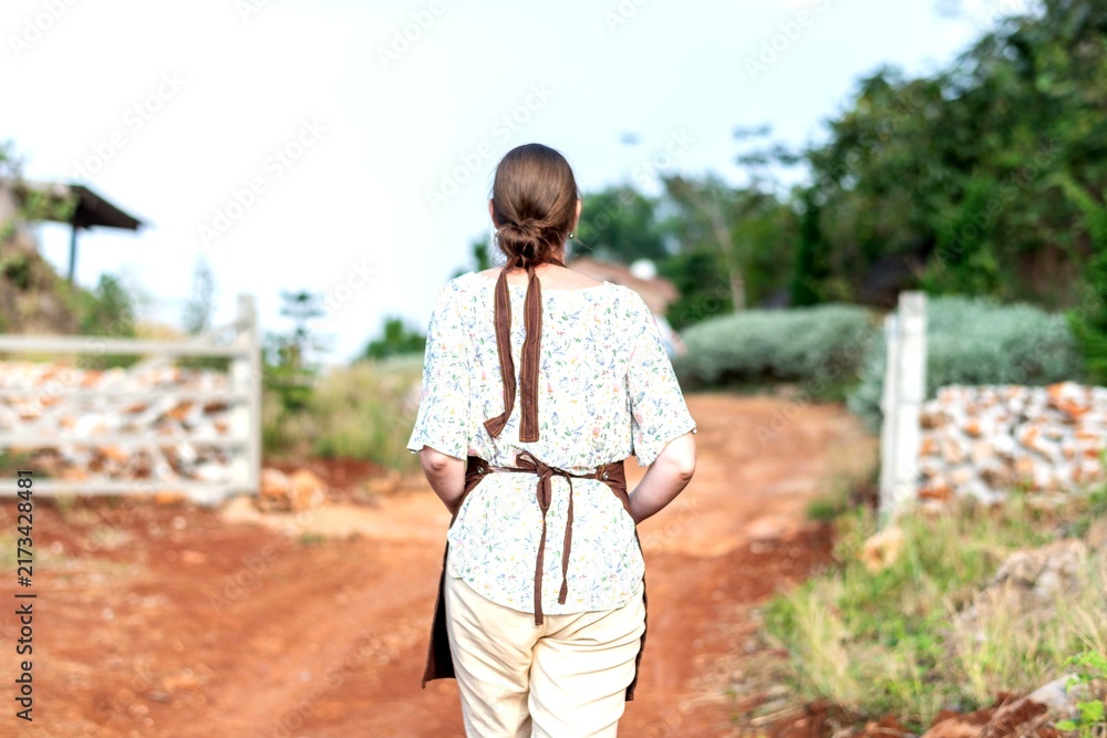 Naklejka premium Woman walking rural dirt path