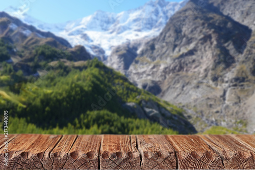 Canvastavla Rustic wooden table with mountain landscape background and copy space