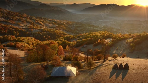 Autumn morning, sunrise over traditional house in Romania, smoke coming out of chimney