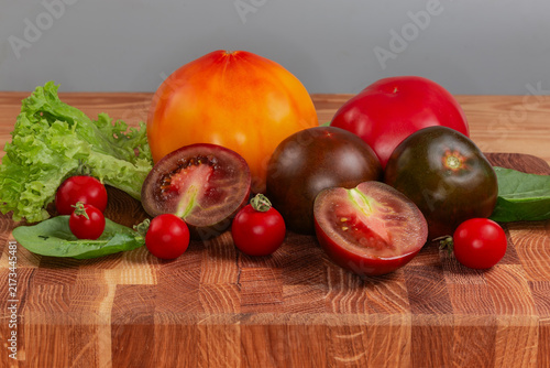 Ripe tomatoes of different varieties on cutting board close-up